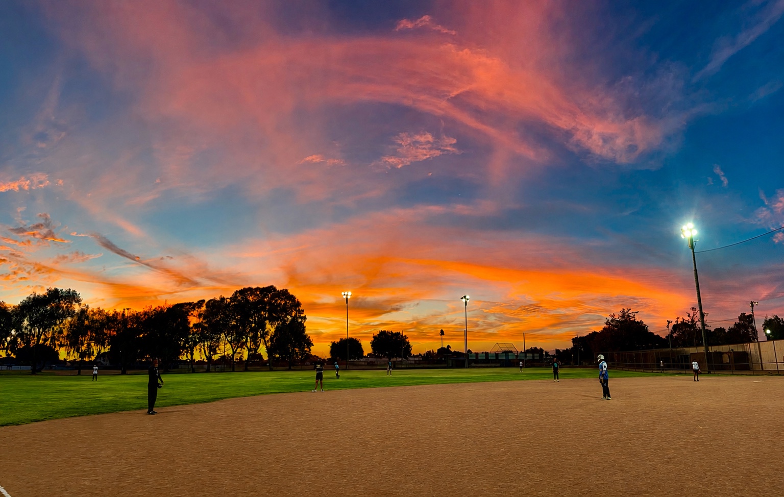 PSTS softball tournament at Edison Park under a colorful sunset